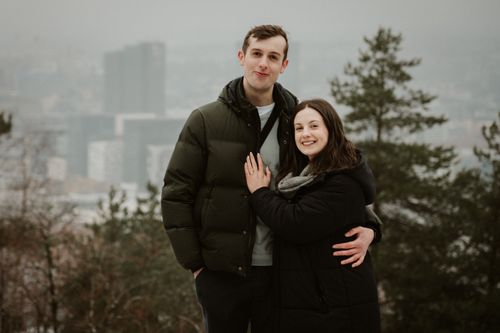 My partner Naomi and I, stood infront of the Oslo skyline. Naomi's hand is placed on my chest, with her solitaire engagement ring visible.